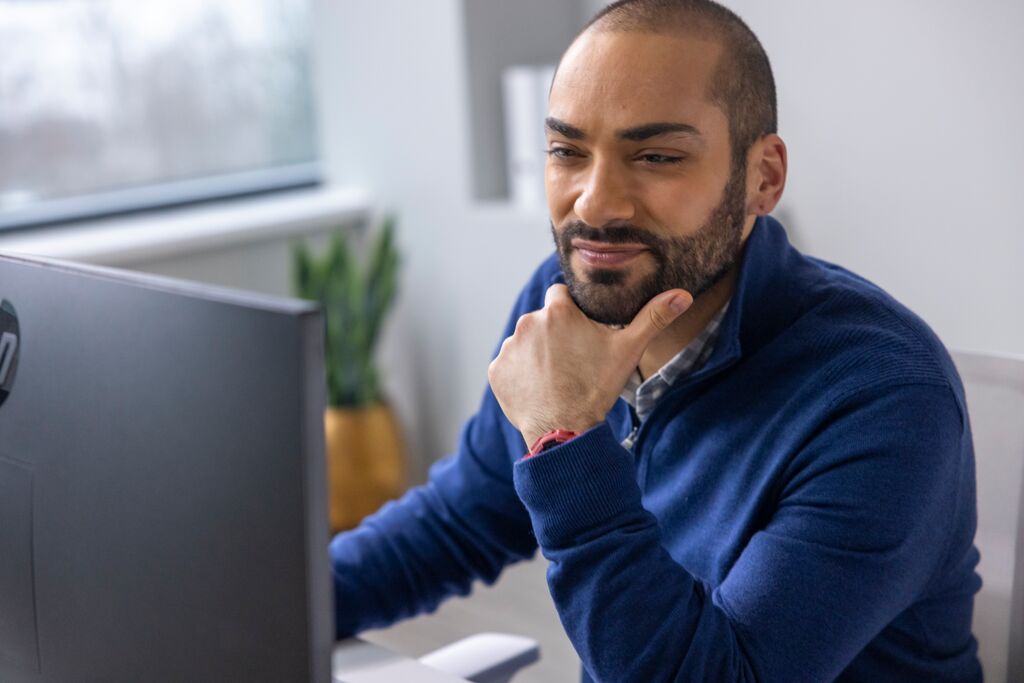 Man looking at computer screen with sales content.